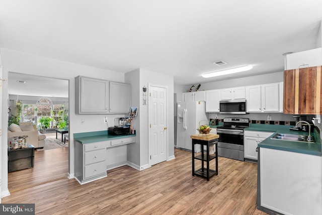 17391 Arrowood Pl, Round Hill, VA 20141 - kitchen featuring stainless steel appliances, light wood-style floors, built in desk, and white cabinets