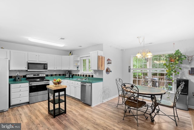 17391 Arrowood Pl, Round Hill, VA 20141 - kitchen with stainless steel appliances, open shelves, light wood-style flooring, and white cabinetry