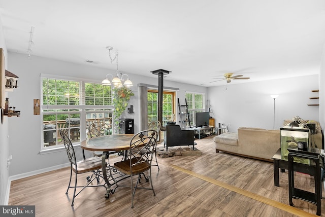 17391 Arrowood Pl, Round Hill, VA 20141 - dining space featuring light wood-type flooring, a ceiling fan, a wood stove, and a chandelier