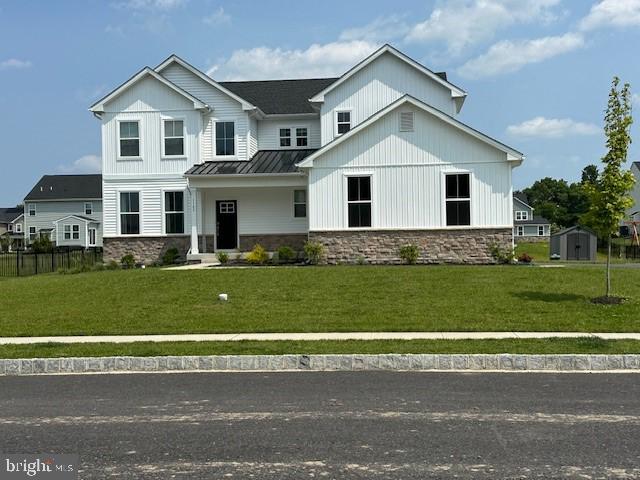 1142 Mariwill Dr, Quakertown, PA 18951 - modern farmhouse featuring stone siding, a standing seam roof, a metal roof, and a shed