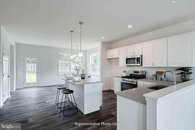61 Glenn Vw, Carlisle, PA 17013 - kitchen featuring appliances with stainless steel finishes, dark wood-type flooring, white cabinets, decorative backsplash, and a kitchen island