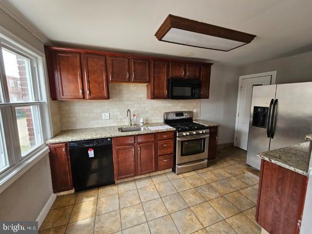 8400 Fayette St, Philadelphia, PA 19150 - kitchen featuring black appliances, decorative backsplash, healthy amount of natural light, and light stone countertops