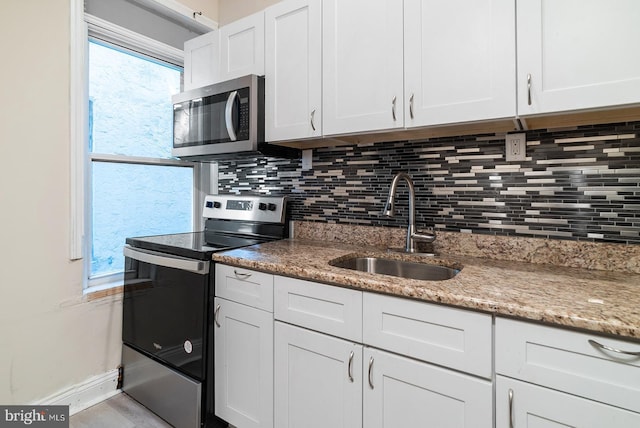 4136 Pennsgrove St, Philadelphia, PA 19104 - kitchen featuring stainless steel appliances, backsplash, white cabinets, and light stone counters