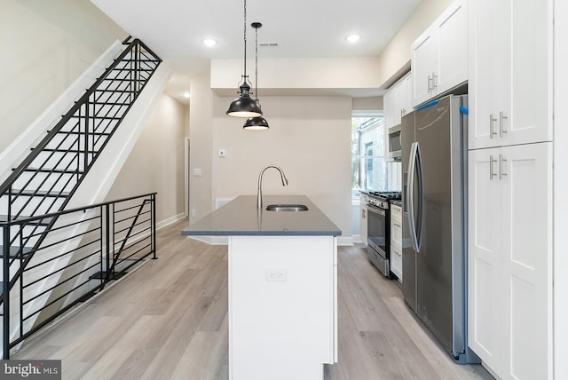 4136 Pennsgrove St, Philadelphia, PA 19104 - kitchen with appliances with stainless steel finishes, a center island with sink, white cabinetry, light wood finished floors, and recessed lighting