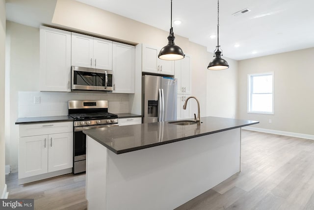 4136 Pennsgrove St, Philadelphia, PA 19104 - kitchen featuring appliances with stainless steel finishes, tasteful backsplash, light wood-style floors, white cabinetry, and recessed lighting