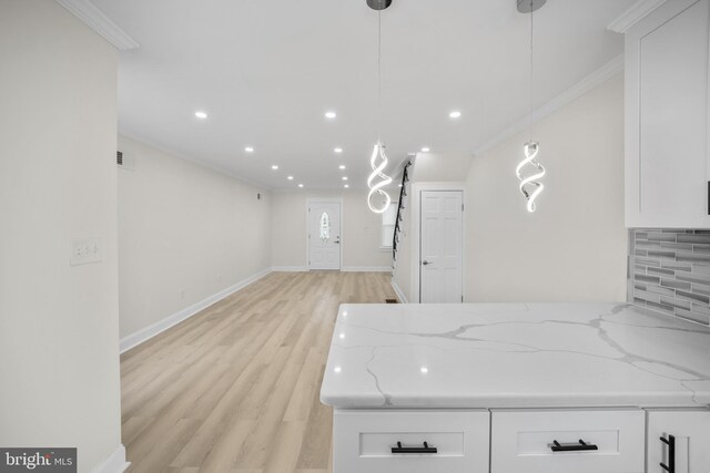 7726 Temple Rd, Philadelphia, PA 19150 - kitchen with white cabinets, tasteful backsplash, crown molding, light stone countertops, and light wood finished floors