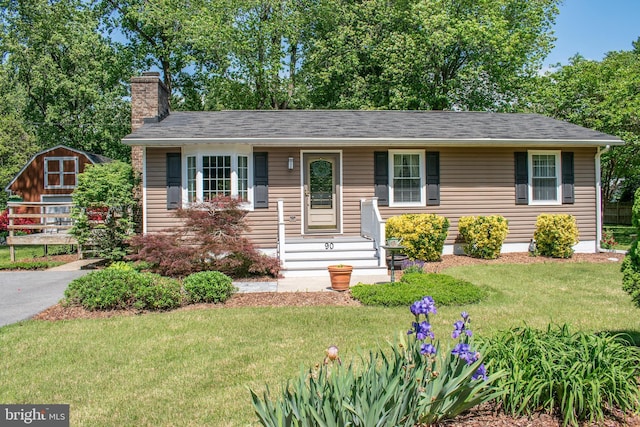 90 Scotts Cove Rd, Edgewater, MD 21037 - view of front facade with a chimney, a front yard, and a shed
