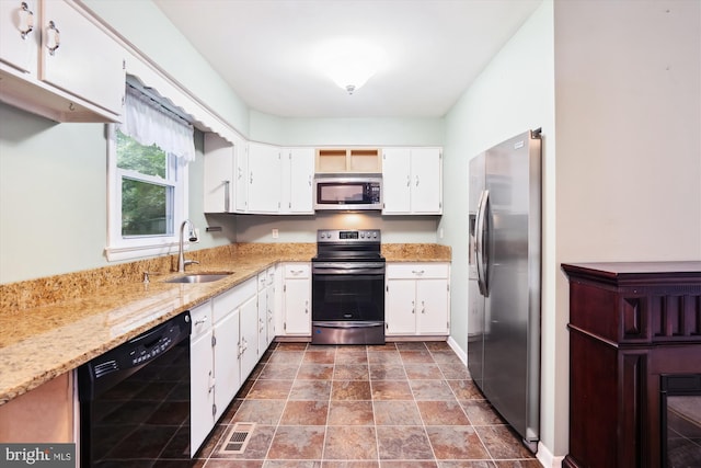 90 Scotts Cove Rd, Edgewater, MD 21037 - kitchen with stainless steel appliances, white cabinetry, light stone counters, and stone finish flooring