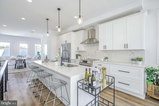 424 Taylor St NW Unit B, Washington, DC 20011 - kitchen featuring wall chimney range hood, stainless steel appliances, backsplash, a kitchen breakfast bar, and recessed lighting