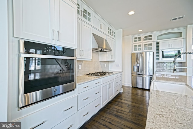 11454 Maull Rd, Lewes, DE 19958 - kitchen with stainless steel appliances, extractor fan, recessed lighting, decorative backsplash, and white cabinetry