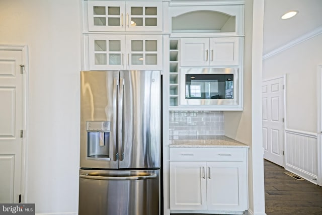 11454 Maull Rd, Lewes, DE 19958 - kitchen with stainless steel fridge, built in microwave, white cabinetry, decorative backsplash, and ornamental molding