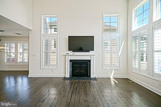 11454 Maull Rd, Lewes, DE 19958 - unfurnished living room featuring plenty of natural light, a high ceiling, a fireplace with flush hearth, and dark wood-type flooring