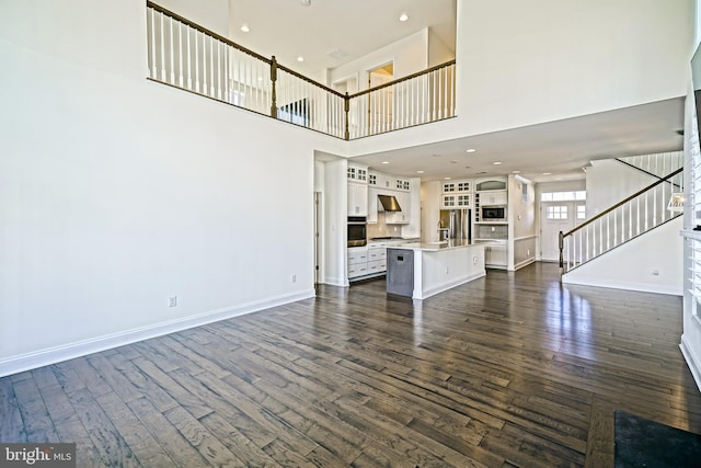 11454 Maull Rd, Lewes, DE 19958 - unfurnished living room featuring stairs, dark wood-style floors, a high ceiling, and recessed lighting