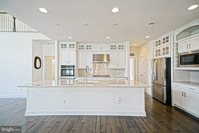 11454 Maull Rd, Lewes, DE 19958 - kitchen with appliances with stainless steel finishes, wall chimney exhaust hood, a center island with sink, dark wood finished floors, and white cabinetry