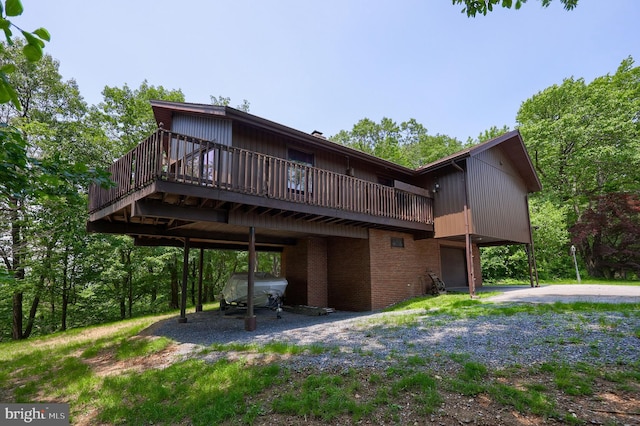 312 Skyline Dr, Reading, PA 19606 - rear view of house with brick siding, a wooden deck, and dirt driveway