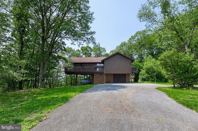 312 Skyline Dr, Reading, PA 19606 - view of front of home featuring an attached garage, driveway, brick siding, a front lawn, and a chimney
