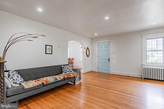 2416 Whitby Rd, Havertown, PA 19083 - living area with radiator, arched walkways, light wood-style floors, and recessed lighting