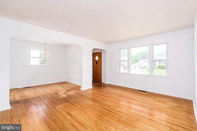 116 Longview Dr, Newark, DE 19711 - spare room with arched walkways, light wood finished floors, and a chandelier