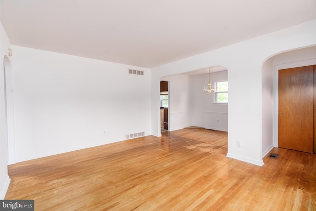 116 Longview Dr, Newark, DE 19711 - spare room with arched walkways, a chandelier, and light wood-style floors