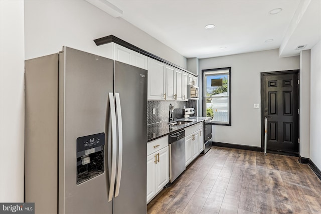 1820 Walbrook Ave, Baltimore, MD 21217 - kitchen with stainless steel appliances, white cabinets, decorative backsplash, wood finished floors, and recessed lighting