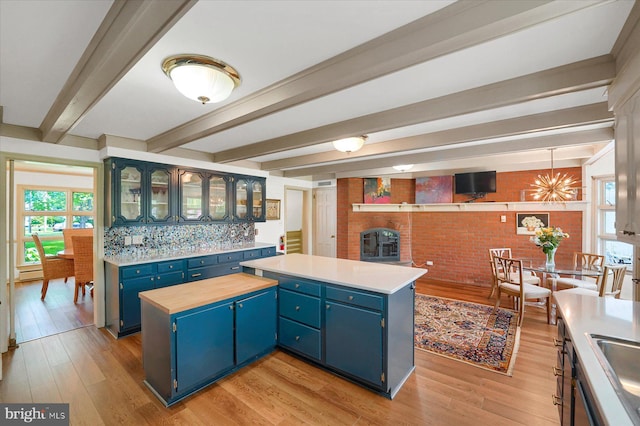 1304 Summit Dr, Bellefonte, PA 16823 - kitchen with blue cabinets, light wood-style flooring, a kitchen island, beam ceiling, and glass insert cabinets