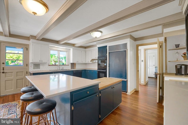 1304 Summit Dr, Bellefonte, PA 16823 - kitchen with paneled built in fridge, blue cabinets, tasteful backsplash, wood finished floors, and a kitchen island