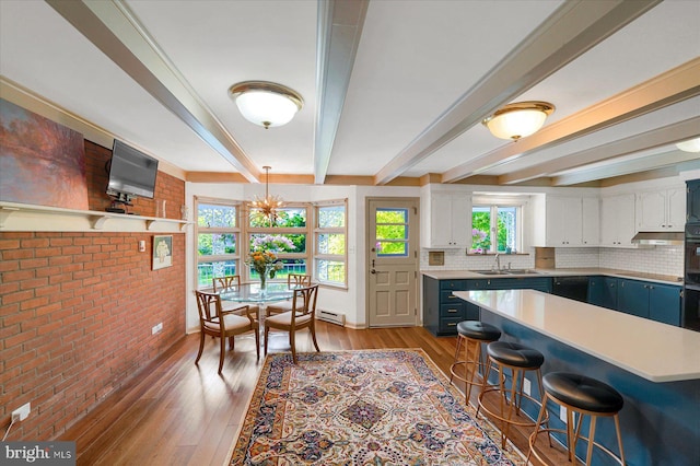 1304 Summit Dr, Bellefonte, PA 16823 - kitchen with beamed ceiling, brick wall, a kitchen breakfast bar, light countertops, and decorative backsplash