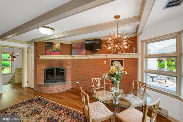 1304 Summit Dr, Bellefonte, PA 16823 - dining room with a chandelier, wood finished floors, beamed ceiling, baseboard heating, and brick wall