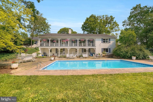 1304 Summit Dr, Bellefonte, PA 16823 - rear view of house with a patio, a lawn, a balcony, an outdoor pool, and a chimney