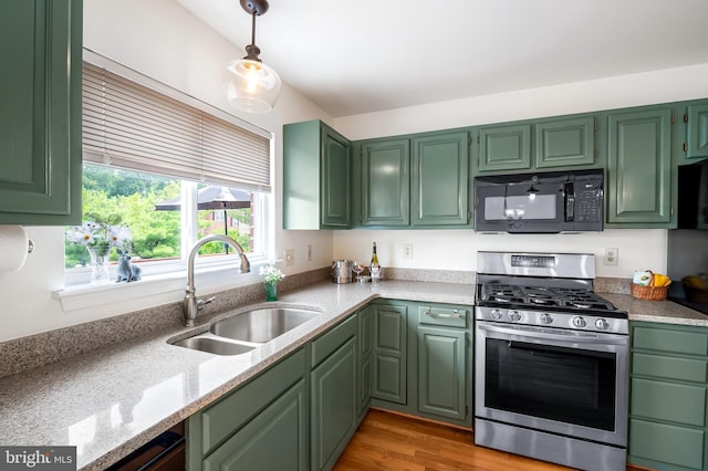 4 Beaver Pond Cir, Baltimore, MD 21234 - kitchen with stainless steel range with gas cooktop, black microwave, green cabinets, hanging light fixtures, and light wood-style floors
