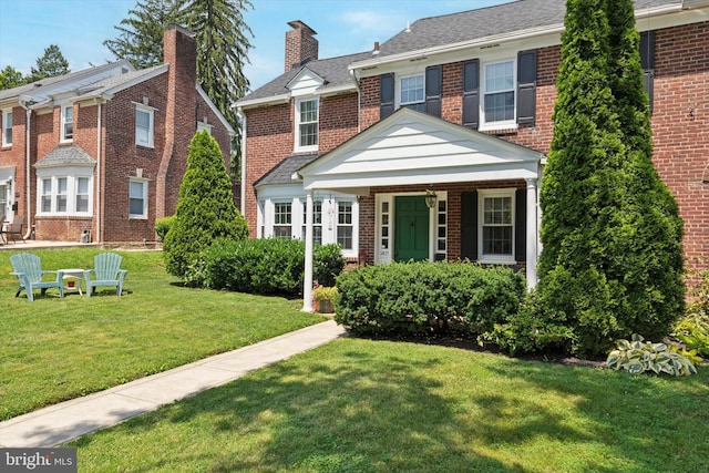 1417 Dorset Ln, Wynnewood, PA 19096 - view of front of home featuring brick siding, a front lawn, and a chimney