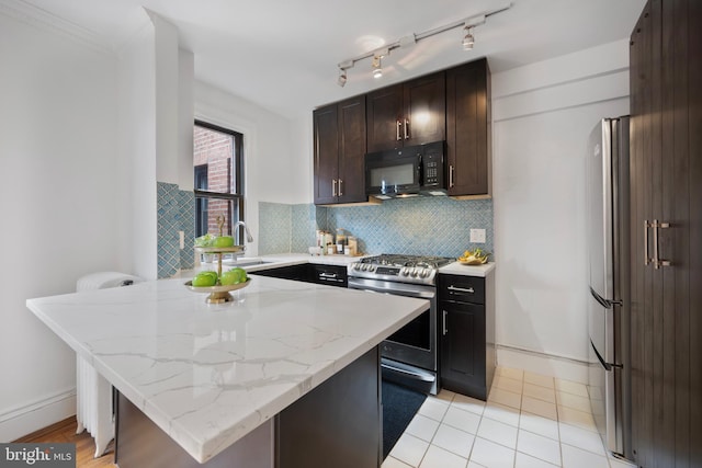 1915 16th St NW Unit 203, Washington, DC 20009 - kitchen with gas range, black microwave, decorative backsplash, light stone countertops, and dark brown cabinets