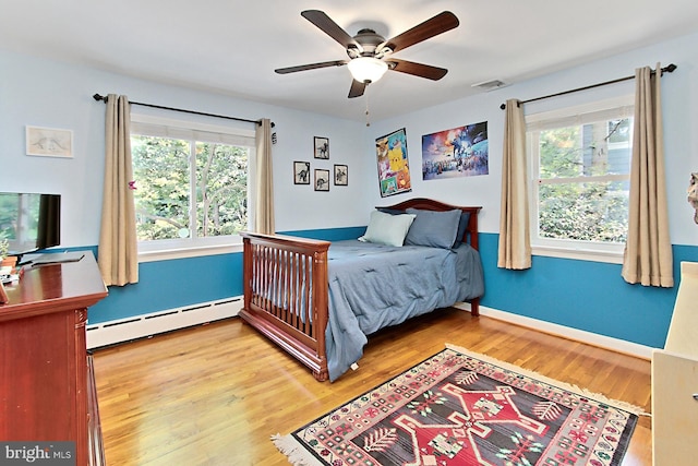 3132 Holmes Run Rd, Falls Church, VA 22042 - bedroom featuring a baseboard radiator, wood finished floors, and a ceiling fan