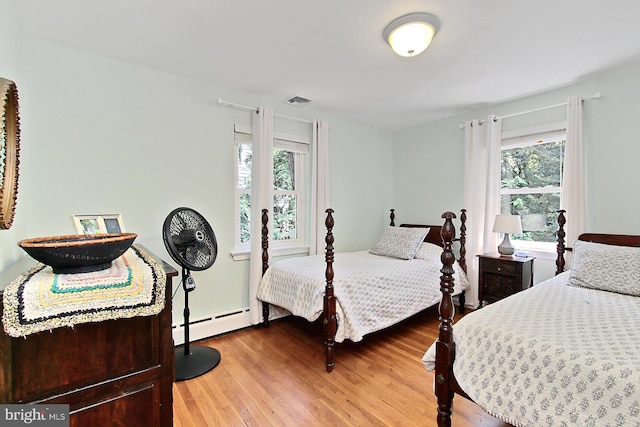 3132 Holmes Run Rd, Falls Church, VA 22042 - bedroom featuring a baseboard heating unit and wood finished floors