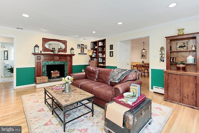 3132 Holmes Run Rd, Falls Church, VA 22042 - living room with a baseboard heating unit, crown molding, light wood-type flooring, recessed lighting, and a fireplace with raised hearth