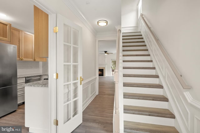 5800 Katelyn Mary Pl Unit 5800, Alexandria, VA 22310 - staircase with a ceiling fan, ornamental molding, a warm lit fireplace, wood finished floors, and a decorative wall