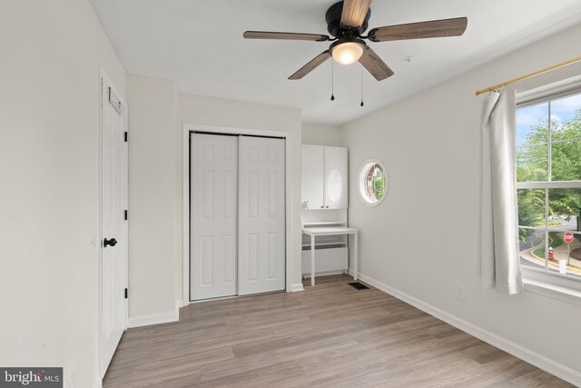 5800 Katelyn Mary Pl Unit 5800, Alexandria, VA 22310 - unfurnished bedroom featuring multiple windows, light wood finished floors, a closet, and a ceiling fan