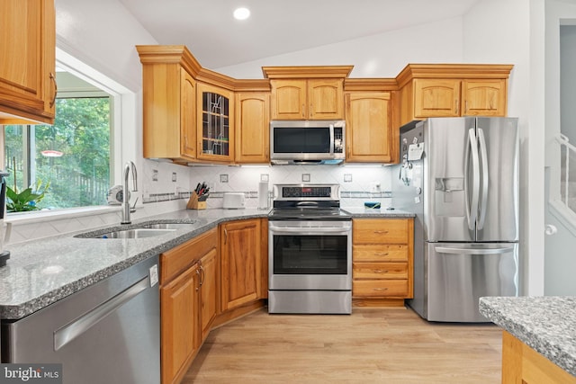 3472 Lyon Park Ct, Woodbridge, VA 22192 - kitchen with stainless steel appliances, vaulted ceiling, stone countertops, tasteful backsplash, and glass insert cabinets