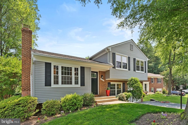 3472 Lyon Park Ct, Woodbridge, VA 22192 - split level home featuring a front lawn, a chimney, and brick siding