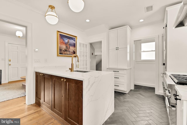 110 E Nelson Ave, Alexandria, VA 22301 - kitchen with high end stainless steel range oven, ornamental molding, white cabinets, light stone counters, and recessed lighting