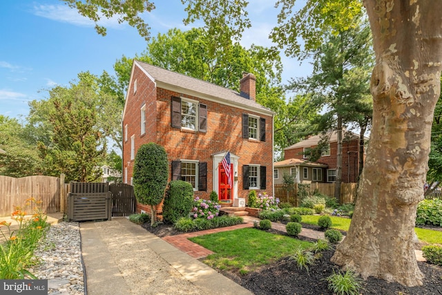 110 E Nelson Ave, Alexandria, VA 22301 - colonial-style house with a chimney, brick siding, a gate, and a shingled roof