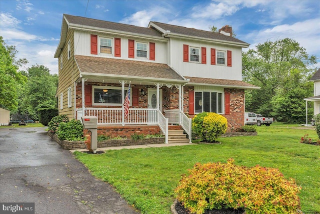 324 W Clayton Ave, Clayton, NJ 08312 - view of front of home with covered porch, a chimney, a front lawn, and driveway