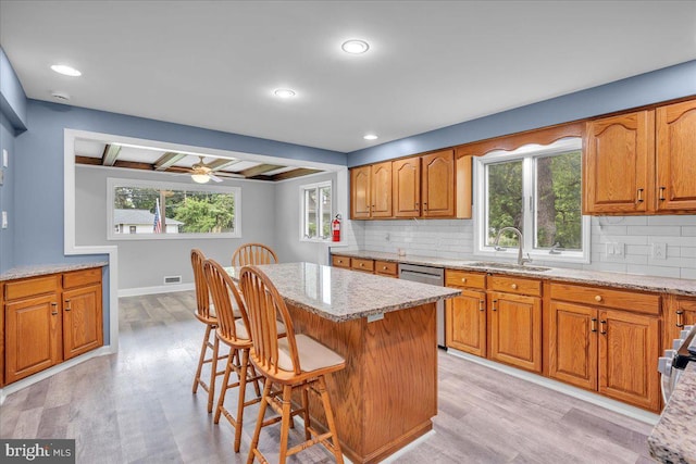 324 W Clayton Ave, Clayton, NJ 08312 - kitchen featuring dishwasher, brown cabinetry, backsplash, light wood-style floors, and light stone counters