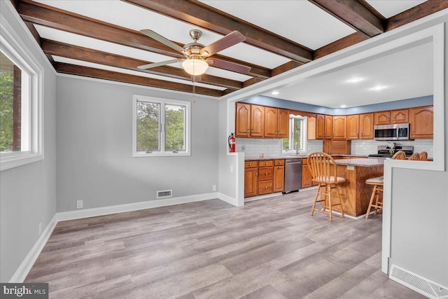 324 W Clayton Ave, Clayton, NJ 08312 - kitchen featuring stainless steel appliances, tasteful backsplash, a breakfast bar area, brown cabinets, and beam ceiling