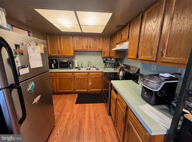 33 Milstone Ct, Sicklerville, NJ 08081 - kitchen with appliances with stainless steel finishes, under cabinet range hood, light wood-style floors, brown cabinets, and light countertops