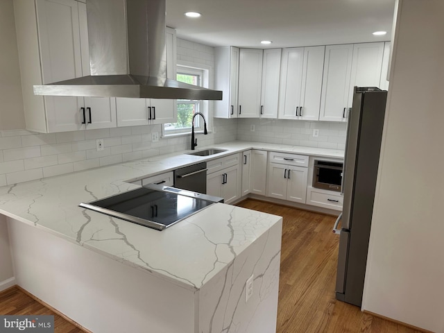 6087 8th Pl N, Arlington, VA 22205 - kitchen with wall chimney exhaust hood, appliances with stainless steel finishes, light wood-type flooring, white cabinetry, and recessed lighting