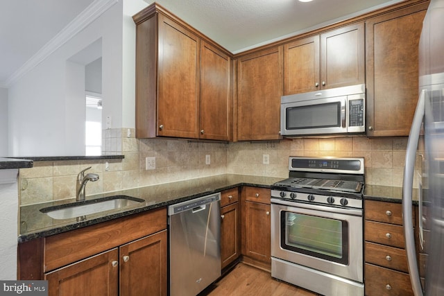 11750 Old Georgetown Unit 2524, Rockville, MD 20852 - kitchen with appliances with stainless steel finishes, crown molding, dark stone countertops, light wood-style floors, and brown cabinetry