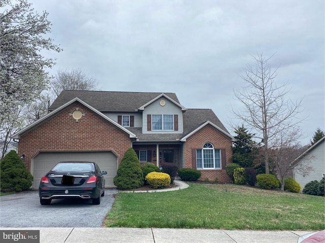 traditional-style home featuring brick siding, asphalt driveway, a front lawn, and an attached garage