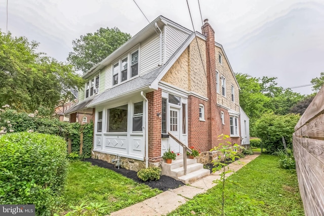 10 W Jefferson St, Media, PA 19063 - view of front of house with entry steps, a chimney, a front yard, and brick siding