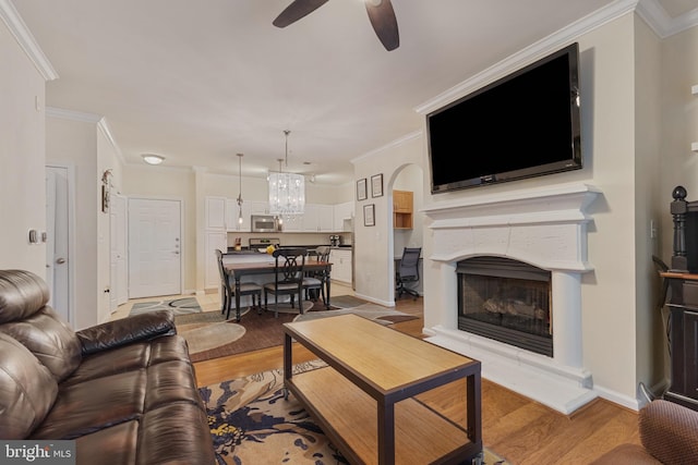 12921 Centre Park Cir Unit 102, Herndon, VA 20171 - living room featuring ceiling fan, light wood-type flooring, a fireplace with raised hearth, ornamental molding, and a chandelier